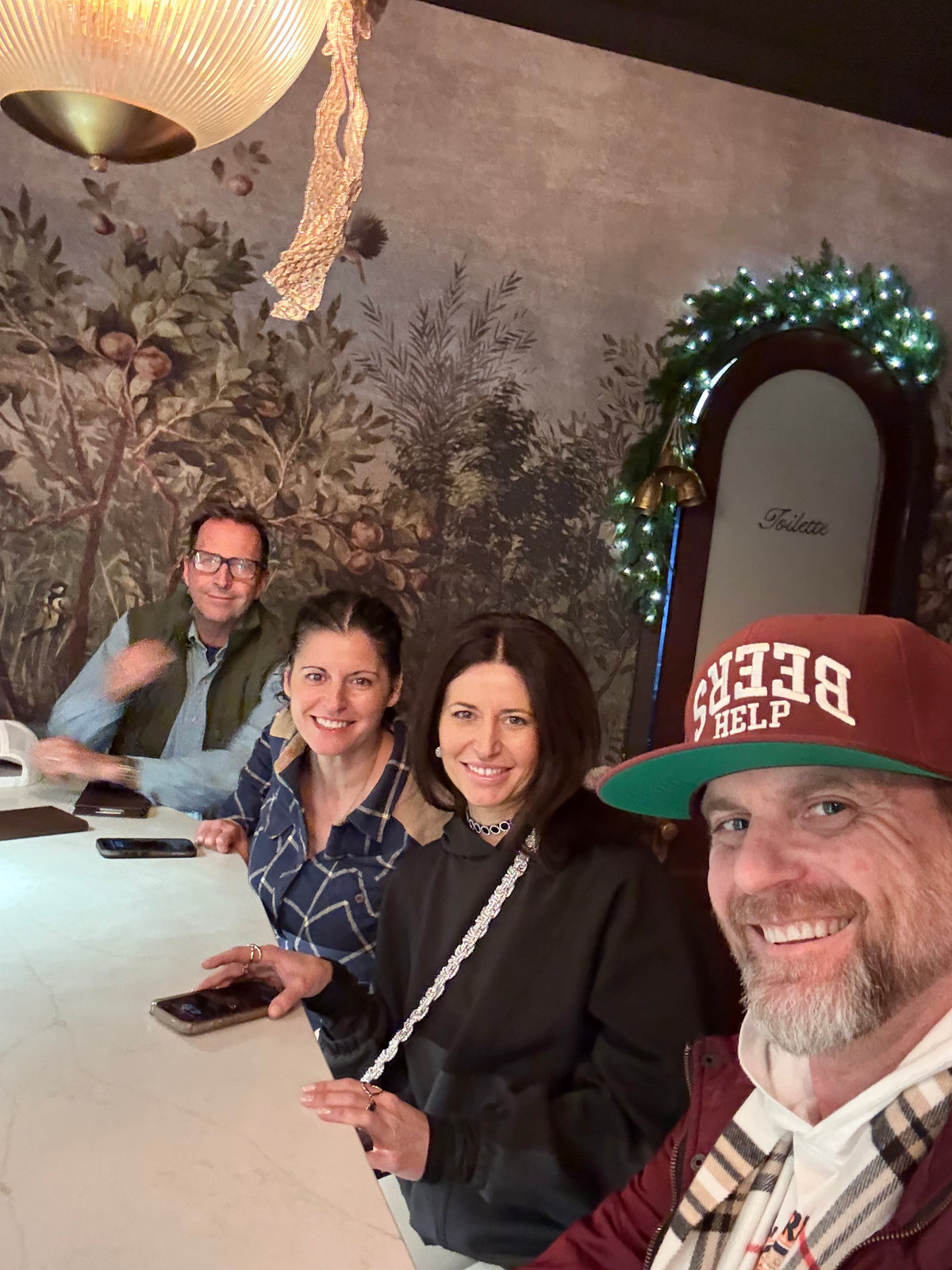 Man wearing a Beers Help hat taking a selfie with friends while enjoying their time together