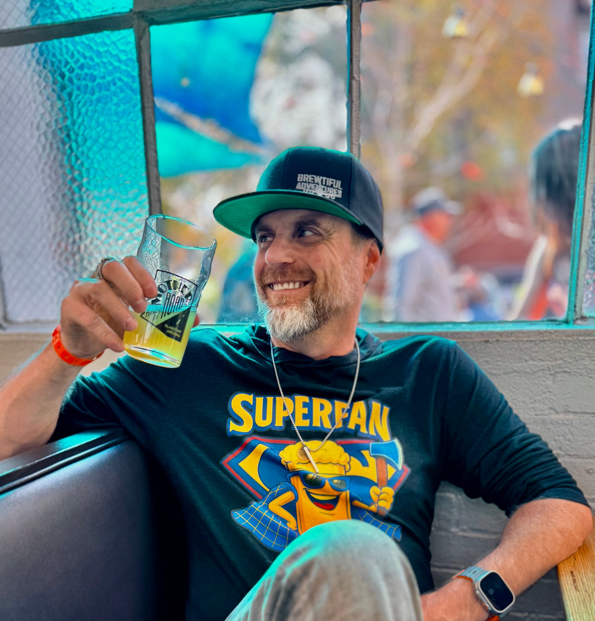 Smiling man holding a beer mug and looking to the side